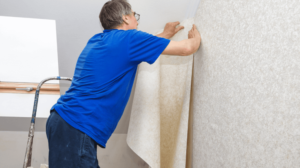 Homme qui pose du papier peint