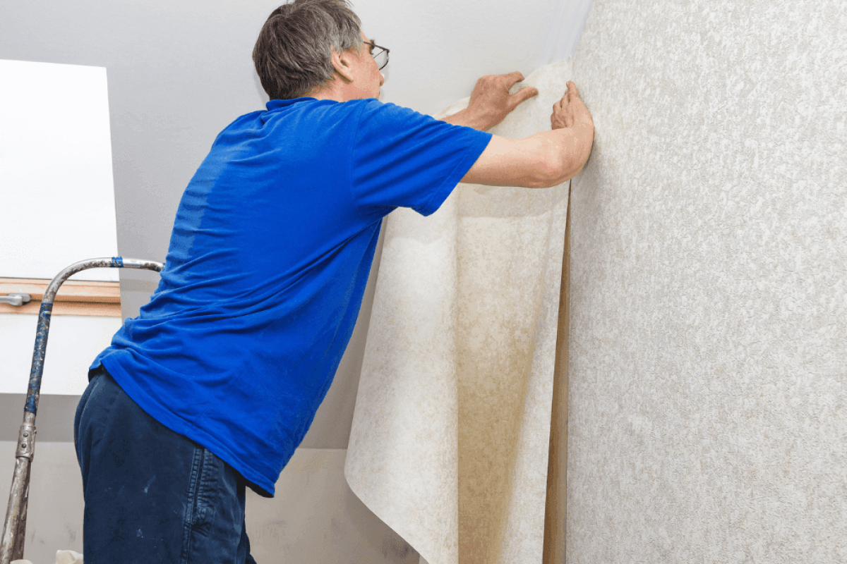 Homme qui pose du papier peint